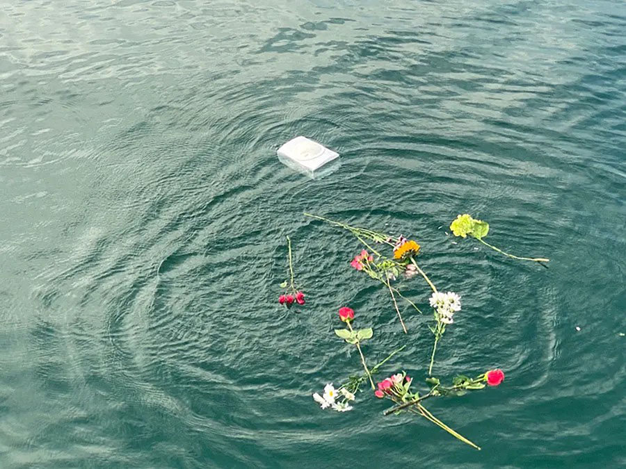 Flowers floating on calm ocean water during an attended burial at sea ceremony in North Carolina